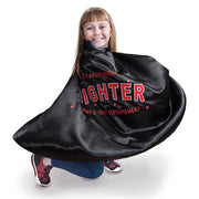 little girl in open the joy's red and black "I'm a fighter" cape