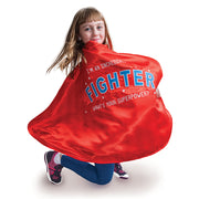 Little girl wearing open the joy's empowering fighter cape for children battling sickness or disease
